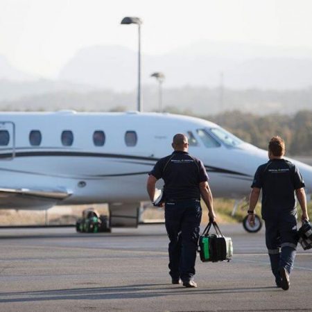 An air ambulance pilot and a medical crew member walking to a jet airplane